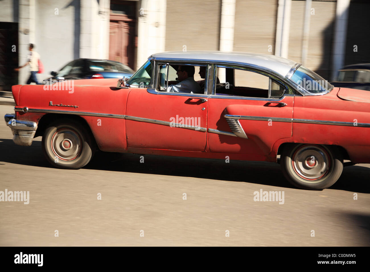 Red car guida attraverso le strade di La Habana Cuba Foto Stock