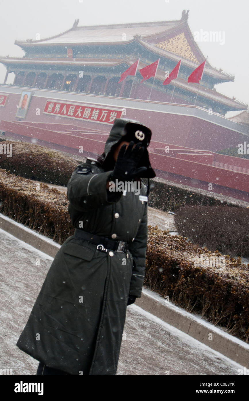 Soldato cinese in piazza Tiananmen ripara il volto dalla telecamera mentre la guardia davanti alla Città Proibita di Pechino Foto Stock