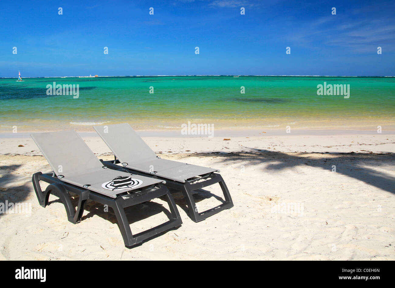 Cappello per il sole sulla chaise longue sulla spiaggia tropicale Foto Stock