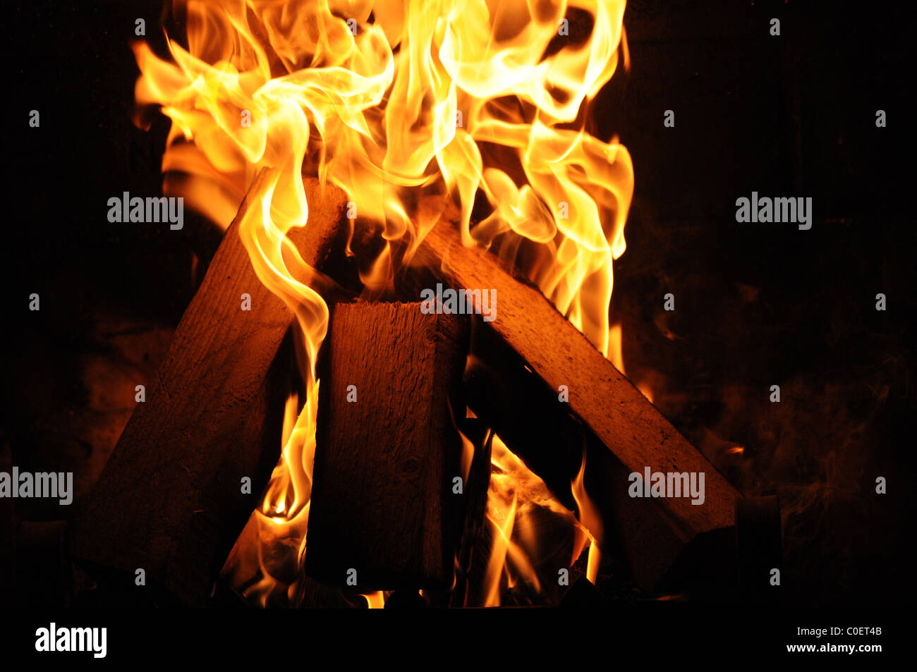 Log fuoco visto bruciare in casa colonica, creando una sensazione di calore e comfort nei freddi mesi invernali. Foto Stock