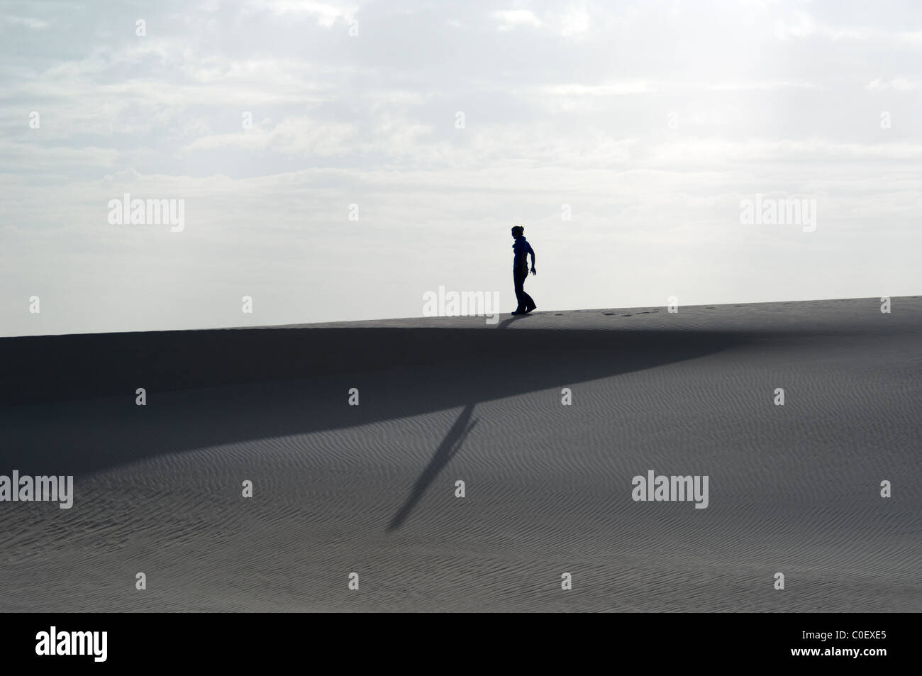 Lone figura in piedi su una duna di sabbia nel deserto del Sahara Foto Stock