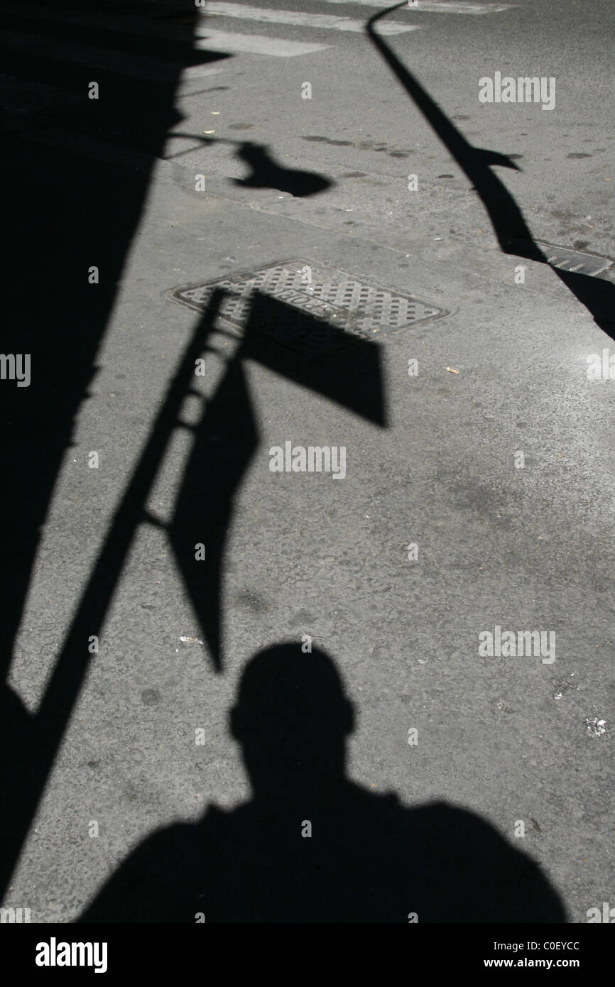 Ombra di uomo in attesa ad una fermata del bus in strada in città Foto Stock