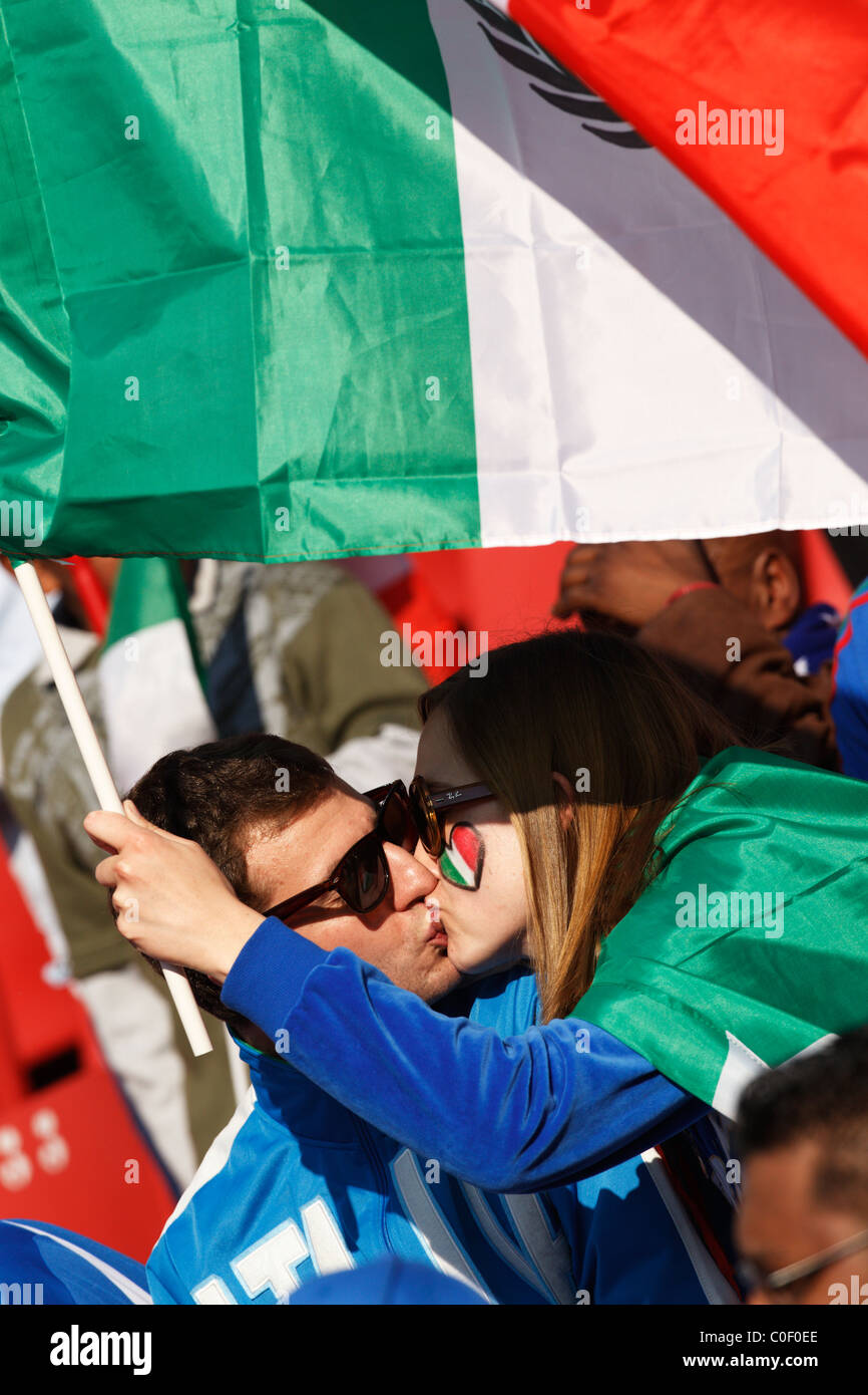 In Italia i sostenitori di baciare e tenendo una bandiera italiana a 2010 FIFA World Cup match tra Italia e Slovacchia il 24 giugno 2010. Foto Stock