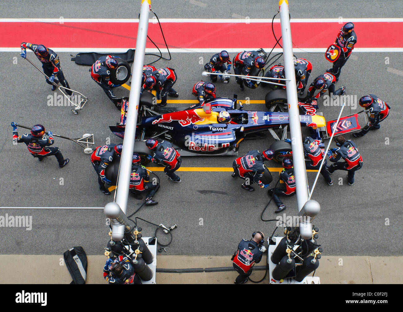 Tedesco di Formula Uno pilota Sebastian Vettel e la Red Bull Pitcrew pratica un pit-stop con la RB7 race car nel febbraio 2011 Foto Stock