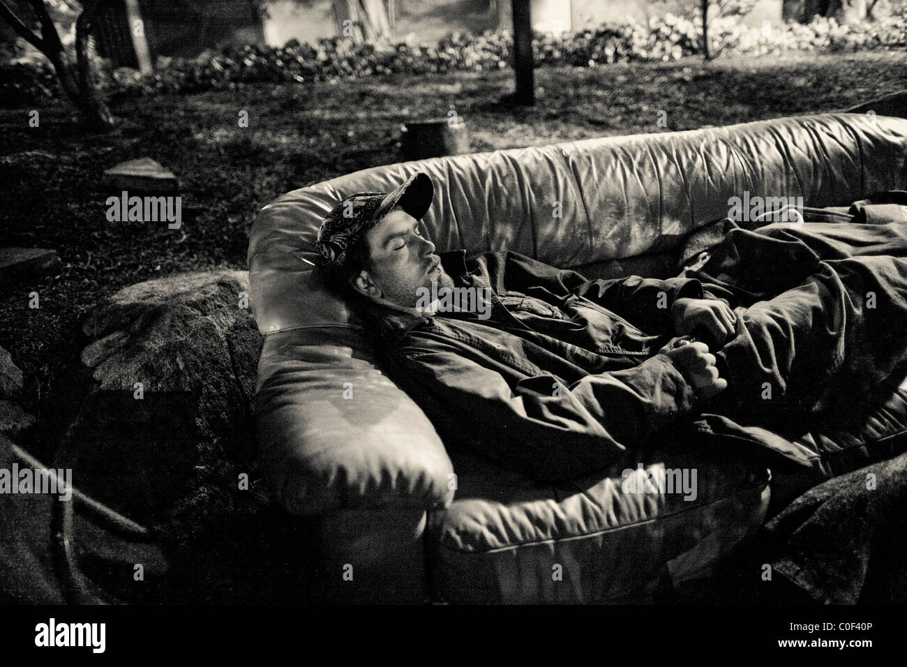 Un senzatetto giovane adulto dorme su un lettino scartato a Seattle il quartiere universitario. Foto Stock