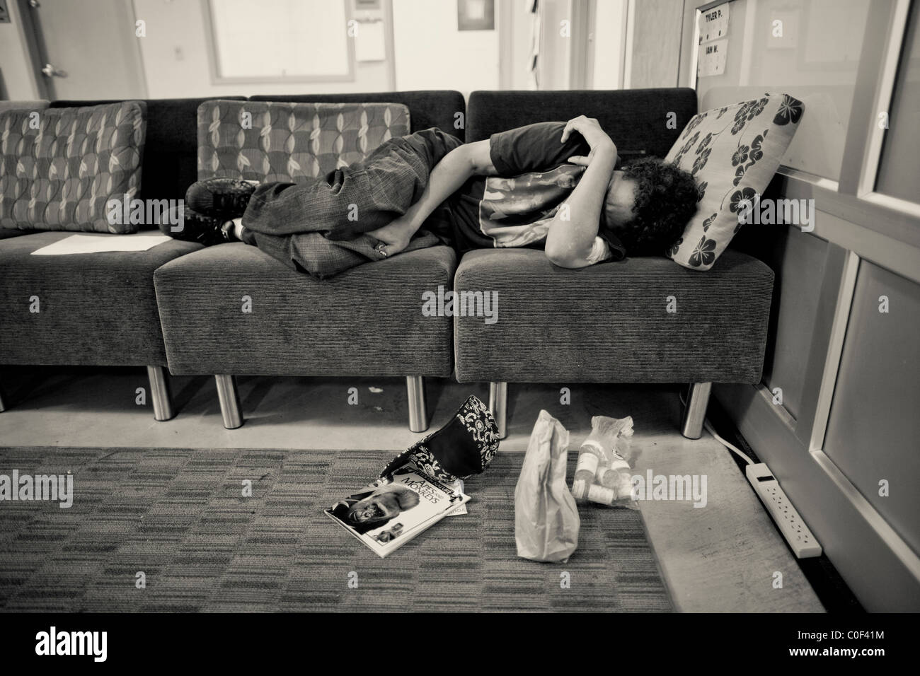 Un senzatetto giovane adulto dorme su un lettino a giovani senzatetto drop-in centro il 10 agosto 2010. Foto Stock