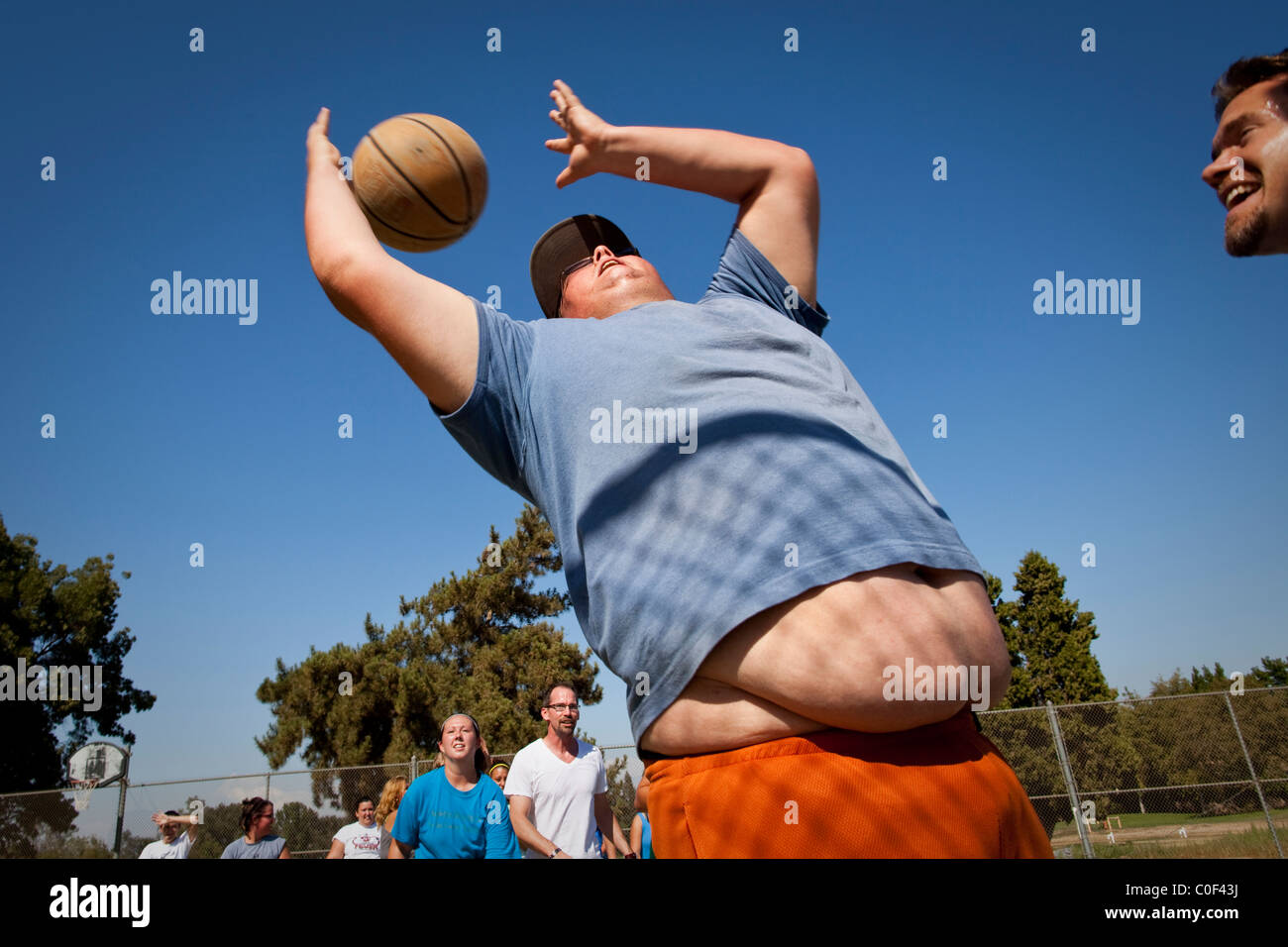 Reedley, California, Stati Uniti. Un obeso adolescente agguanta un rimbalzo durante una partita di basket a Fonte Academy, un cinghiale Foto Stock