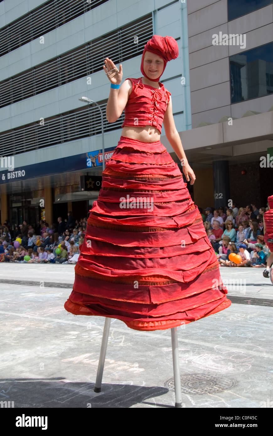 Giovane ragazza su palafitte, di Natale Credit Union Pageant attraverso le strade di Adelaide, Australia del Sud. Foto Stock