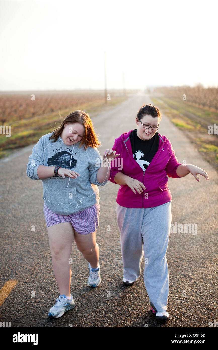 Reedley, California, Stati Uniti. Ragazze obesi cantare la musica durante una passeggiata mattutina a Fonte Academy, una scuola fo Foto Stock