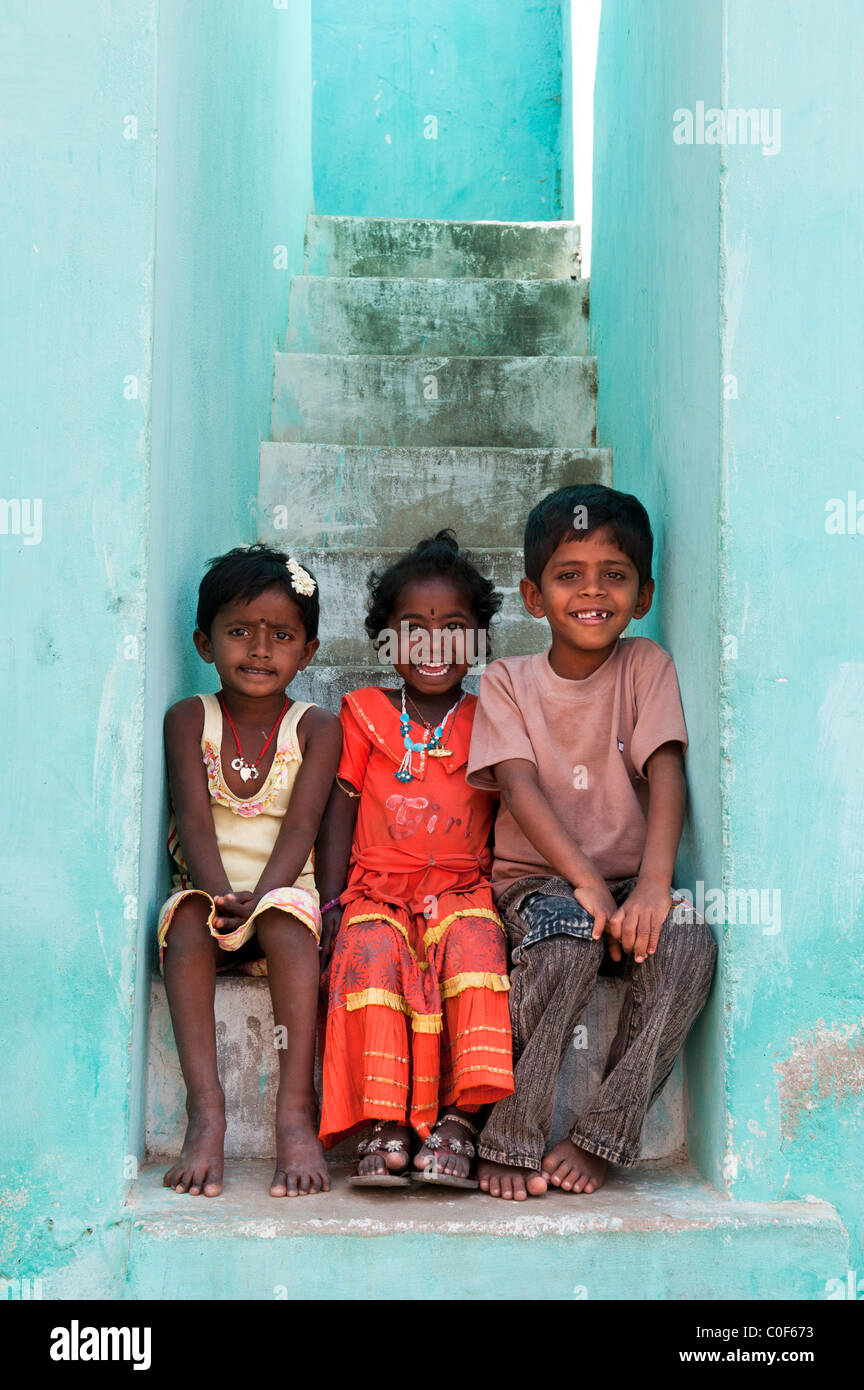 Sorridendo felice villaggio indiano bambini seduti su alcuni passaggi. Andhra Pradesh, India Foto Stock