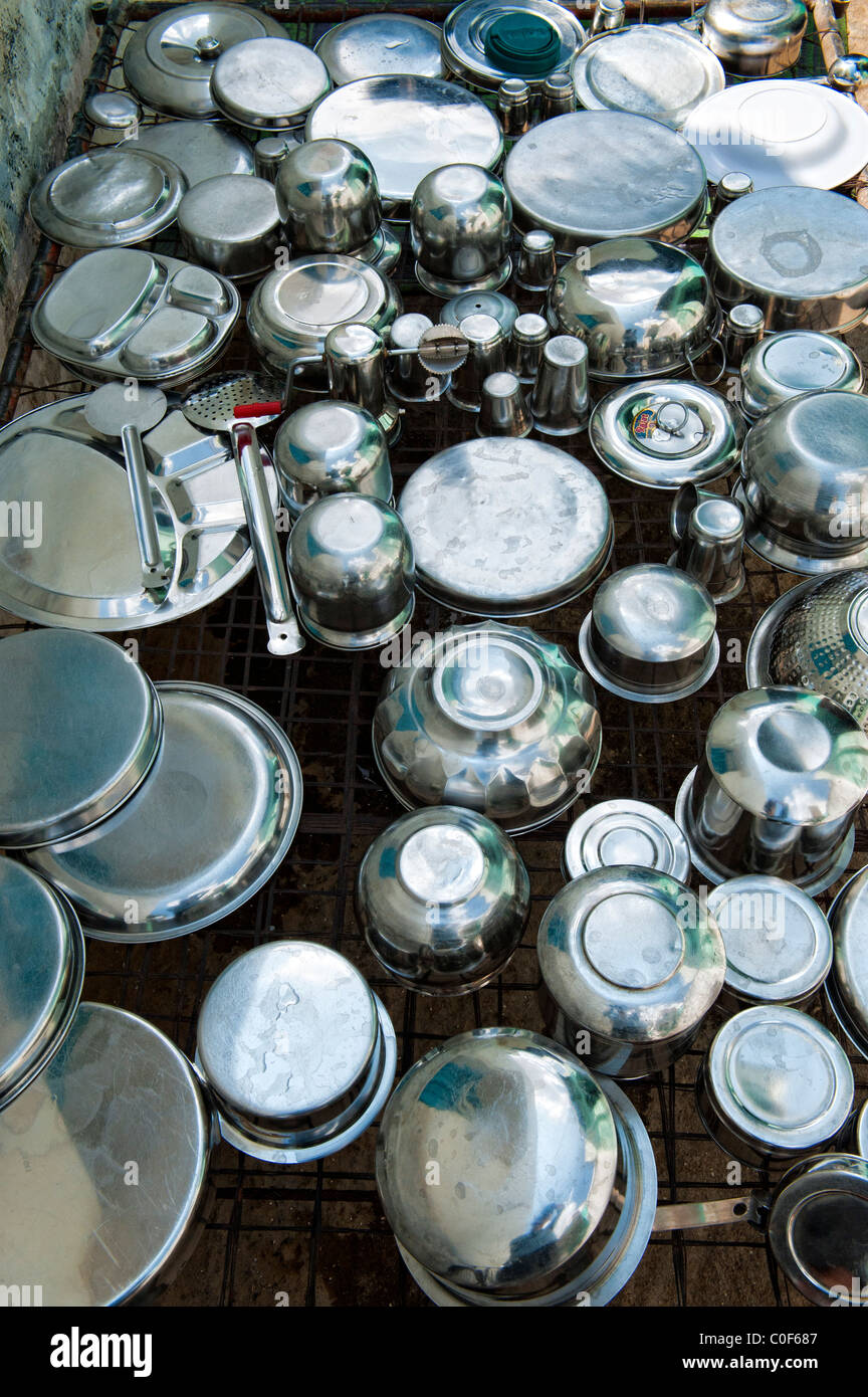 Indian metallica in acciaio inox pentole, utensili da cucina di essiccazione al sole dopo essere stato lavato. Andhra Pradesh, India Foto Stock
