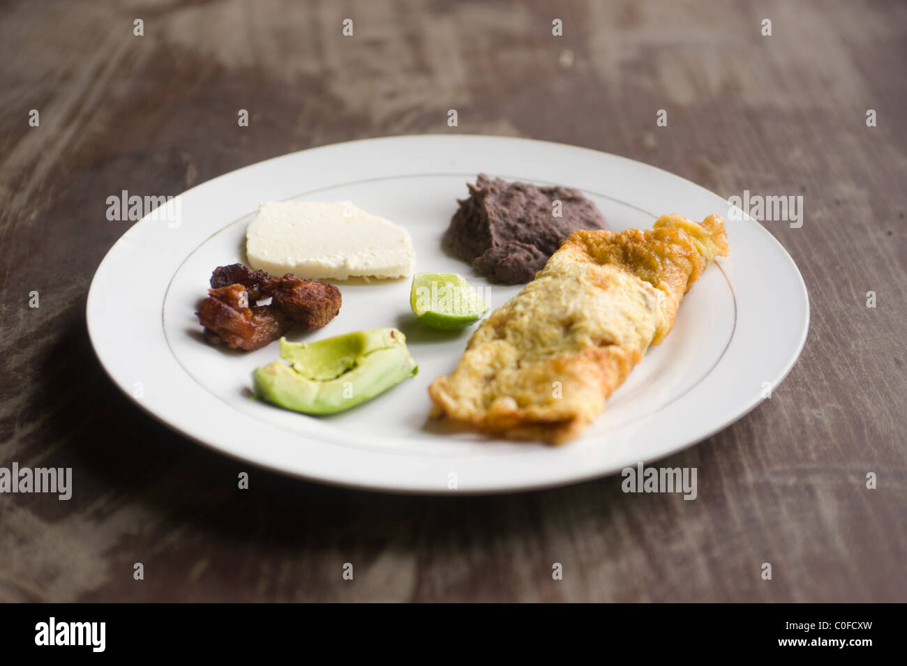 Omelete honduregno ripiene di verdure locali, refried fagioli, formaggio fresco, Chicharrón, avocado, e calce Foto Stock