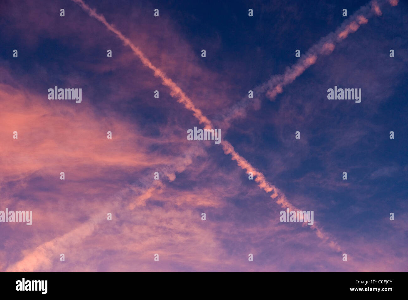 Scenic visuale del cielo con le Nuvole rosa e X forma traccia lasciata da aerei al tramonto, Miami Beach, Florida, Stati Uniti d'America Foto Stock