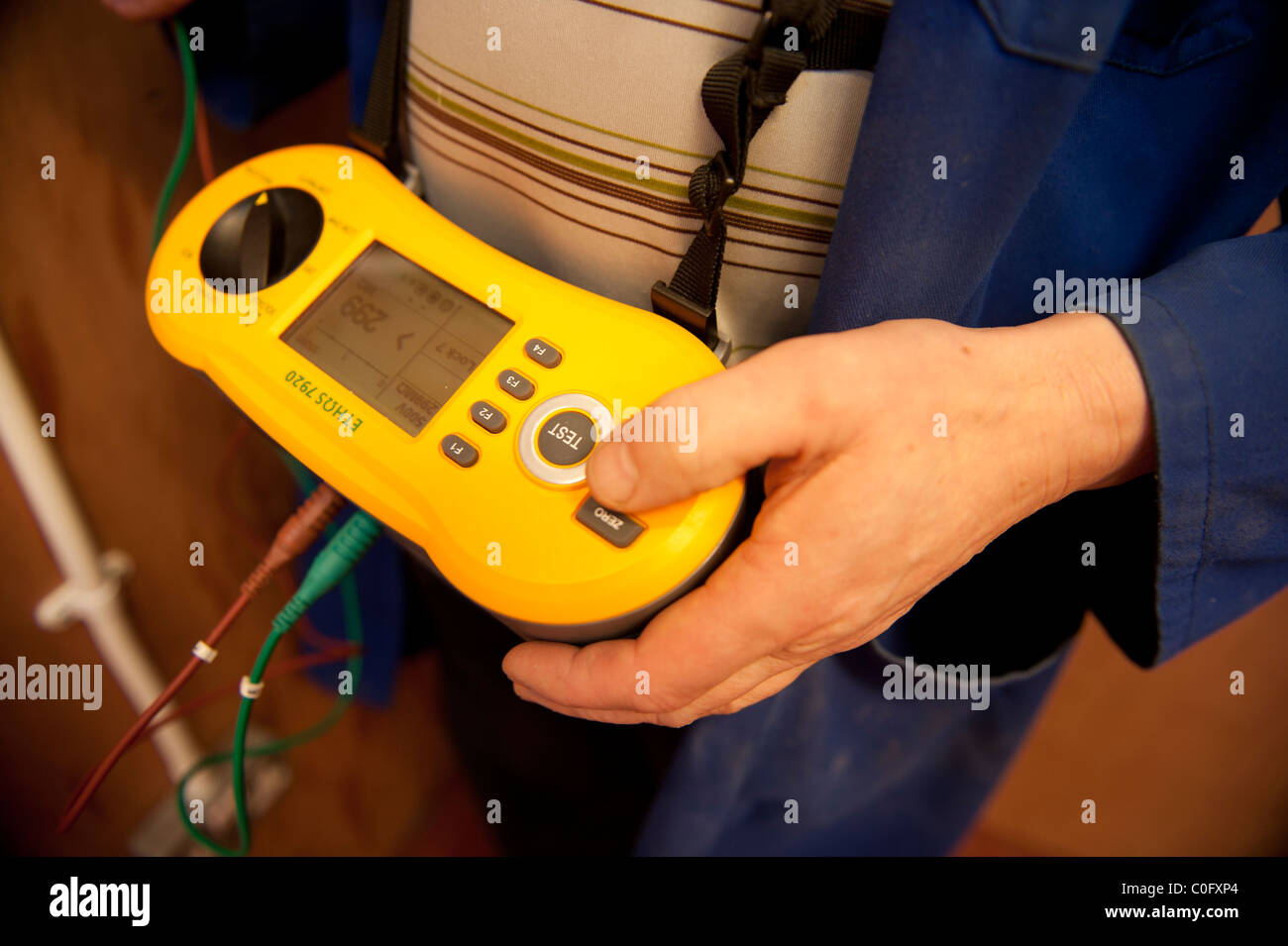 Un elettricista a lavorare test PAT un apparecchio elettrico, REGNO UNITO Foto Stock