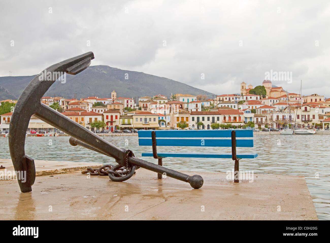 Una vista della città storica di Galaxidi, Grecia, dal lato opposto della baia, avente un vecchio elemento di ancoraggio in primo piano Foto Stock