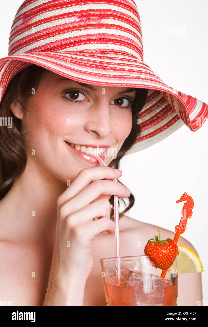Giovane bella donna è bere un cocktail di frutta Foto Stock