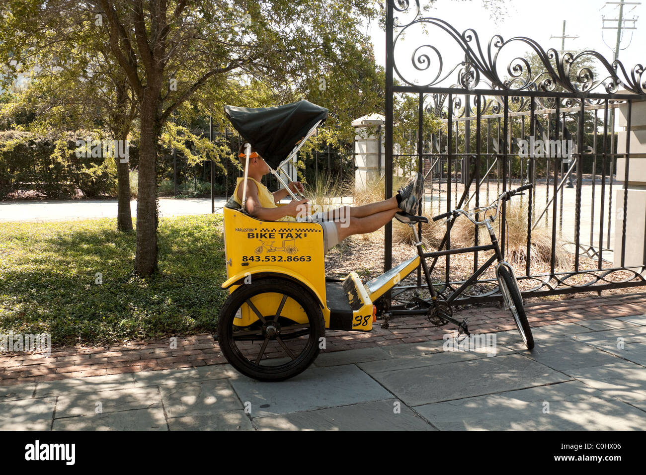 Pilota pedicab in appoggio con i piedi di Charleston, Carolina del Sud e Stati Uniti d'America Foto Stock