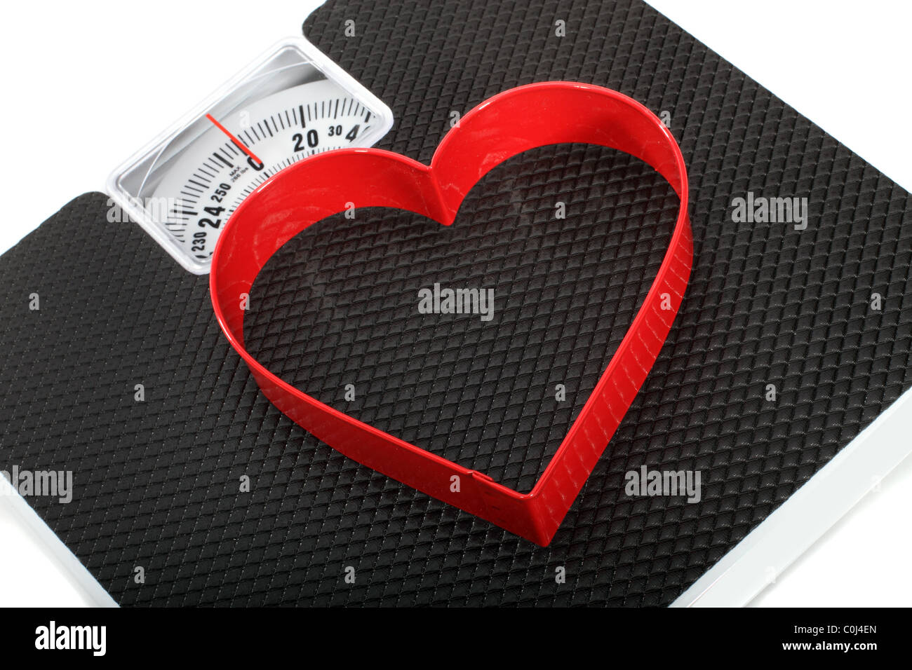 Bilancia da bagno con un cuore rosso simbolo sagomato per un concetto su uno stile di vita sano Foto Stock