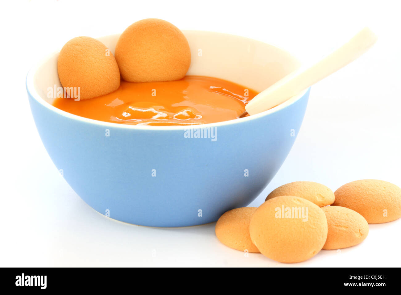 Vista ravvicinata di hot baby frutta pap /poltiglia in vaso blu - con diversi pan di biscotti Foto Stock