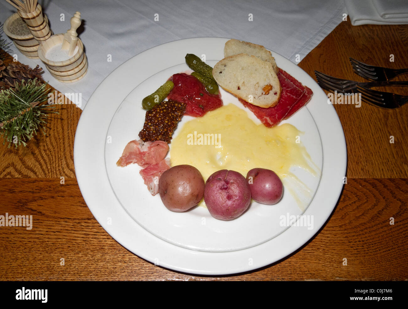 Piatto di formaggio raclette e di verdure a pranzo con caminetto a cena, Deer Valley, Utah. Foto Stock