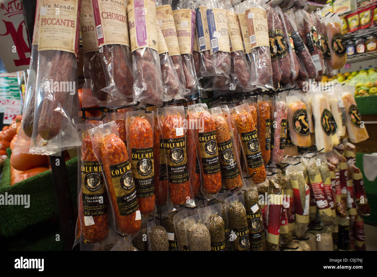 Una selezione di salumi italiani e altri salumi appesi in un negozio di alimentari in New York Foto Stock