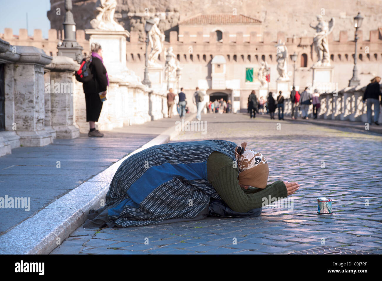 Zingaro femmina mendicante disteso sul marciapiede di Ponte Sant'Angelo, Roma. Foto Stock