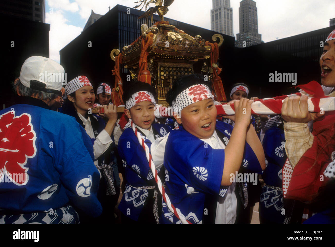 Japanese-Americans bambini portano un santuario in processione per la loro Omikoshi (Raccolto) Festival di New York Foto Stock