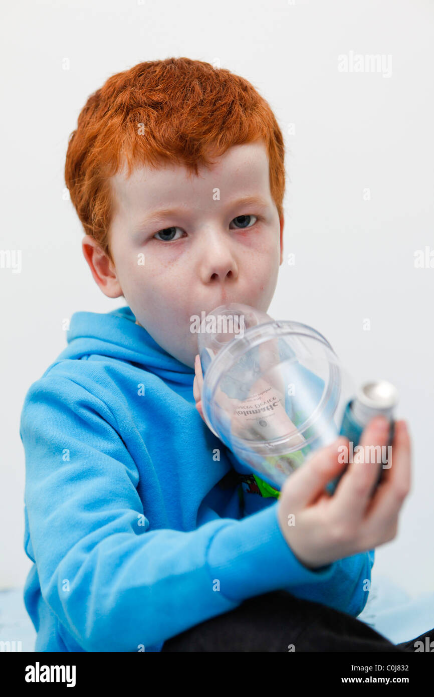 Little Boy utilizzando la sua asma inalatore per alleviare i sintomi. Foto Stock