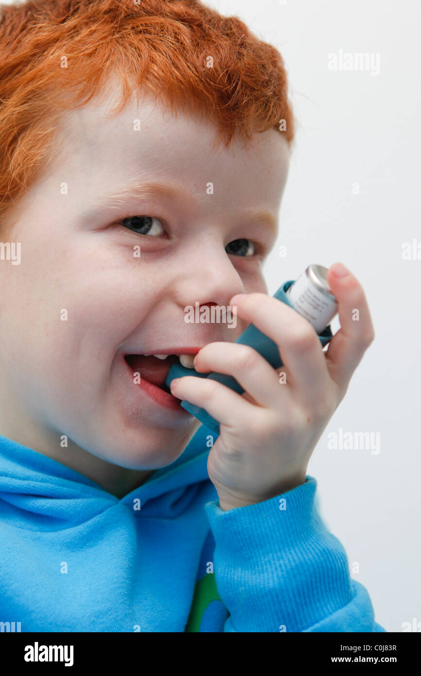 Little Boy utilizzando la sua asma inalatore per alleviare i sintomi. Foto Stock