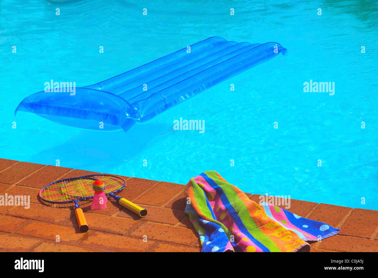 Piscina con lilo blu e un giardino badminton set. Foto Stock