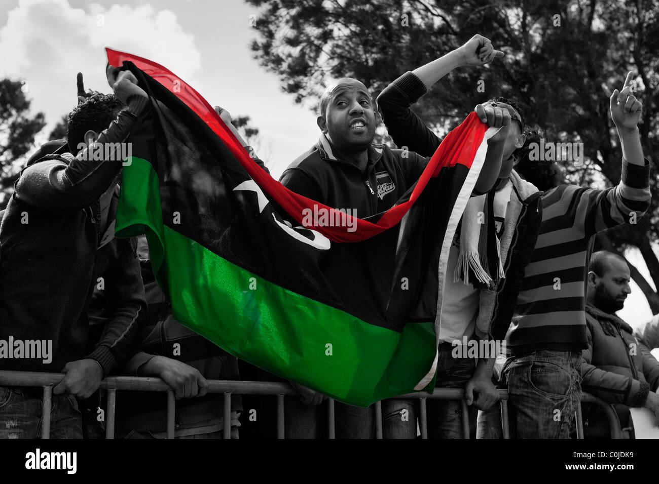 ATTARD, MALTA - FEB 22 - Libyan anti-Gheddafi manifestanti onda il funzionario bandiera libica durante una manifestazione di protesta Foto Stock