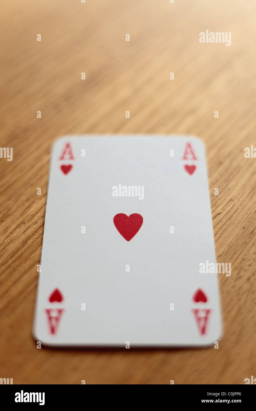 Un asso di cuori La carta da gioco su un tavolo di legno. Messa a fuoco  selettiva rileva il centro della carta Foto stock - Alamy