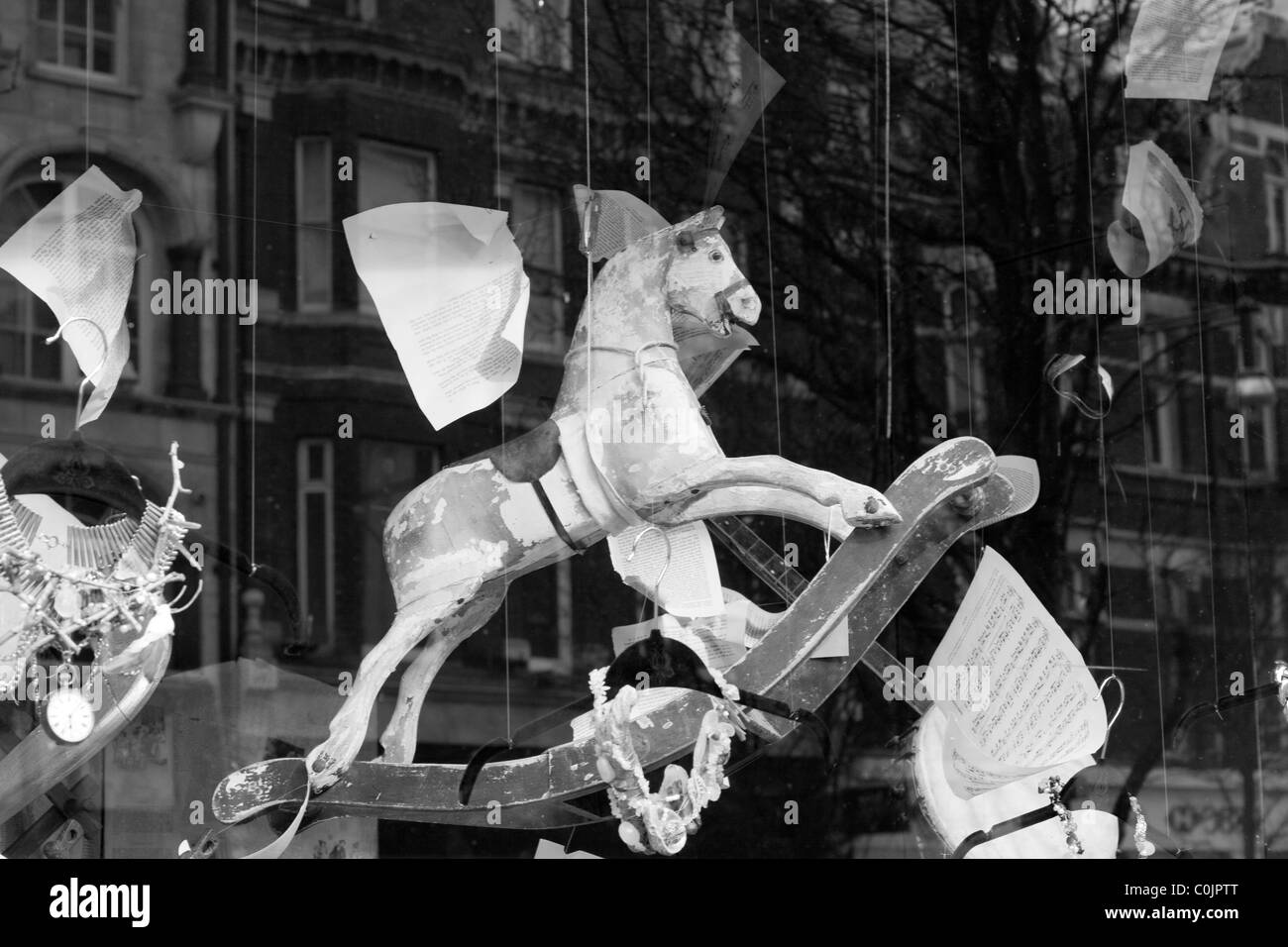 Vecchio cavallo a dondolo in un giocattolo negozio finestra Foto Stock
