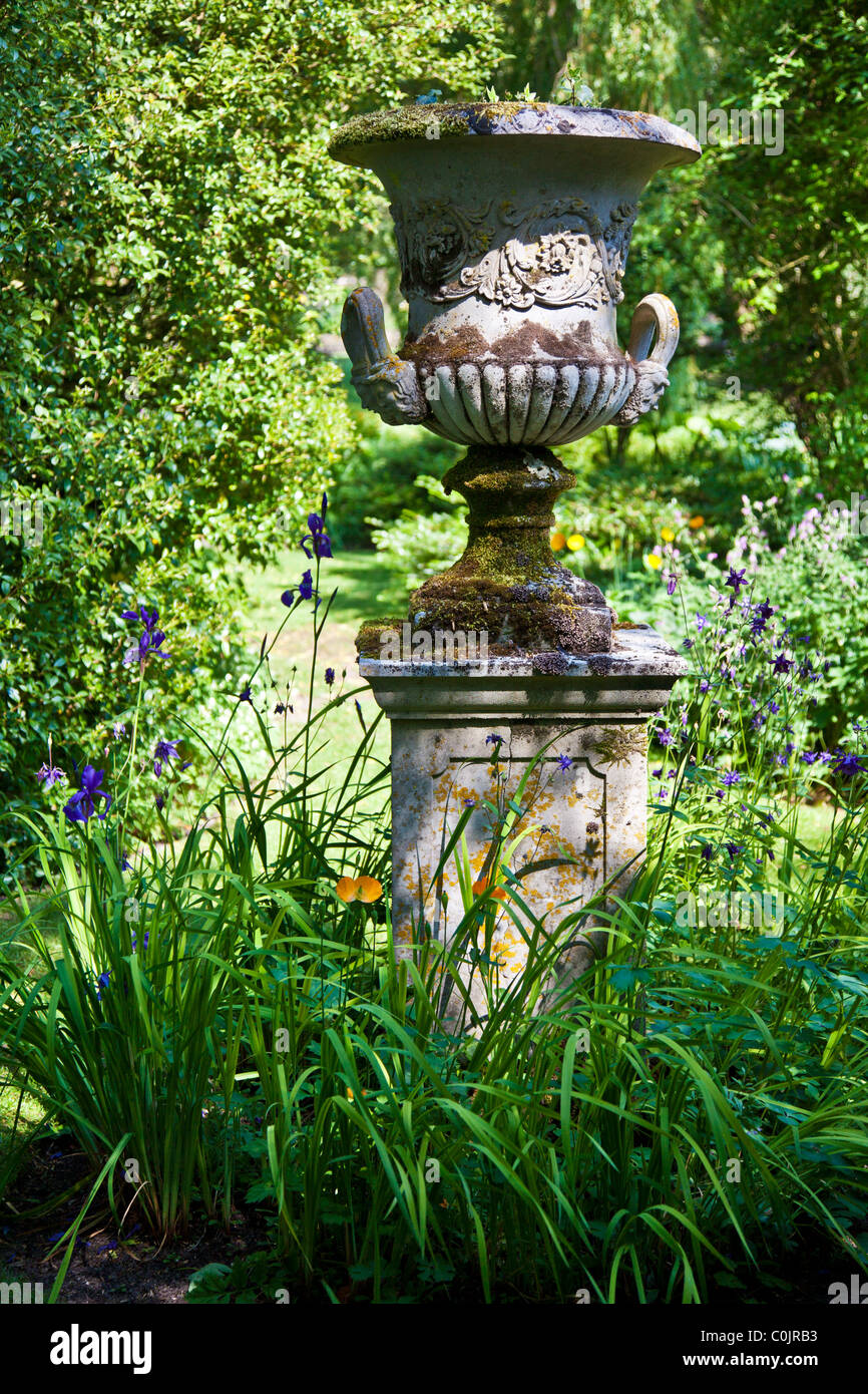 Una pietra ornamentale urn su uno zoccolo in un paese di lingua inglese il giardino. Foto Stock