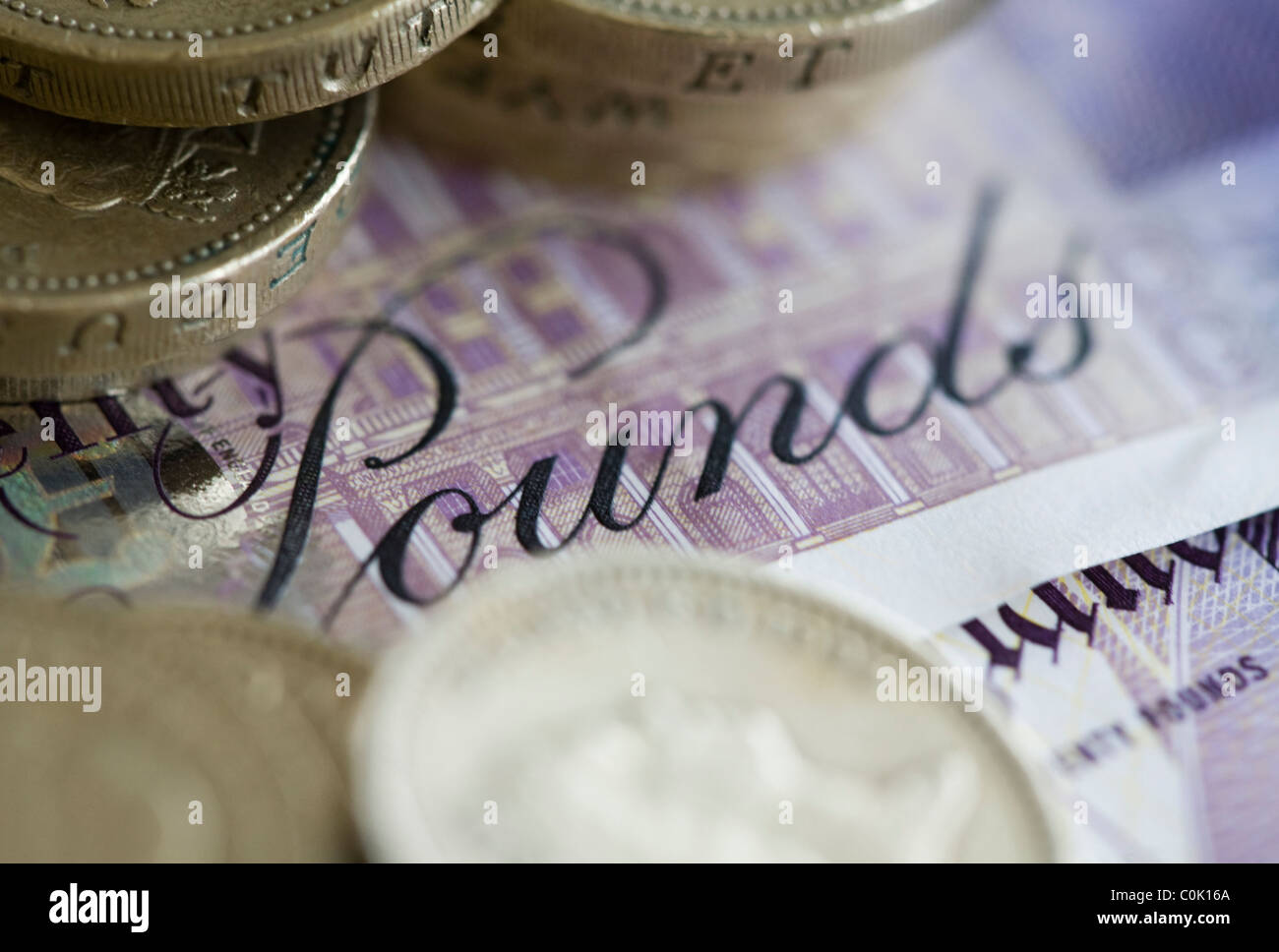 Venti sterline note e una libbra di monete sono impostati per una fotografia Foto Stock