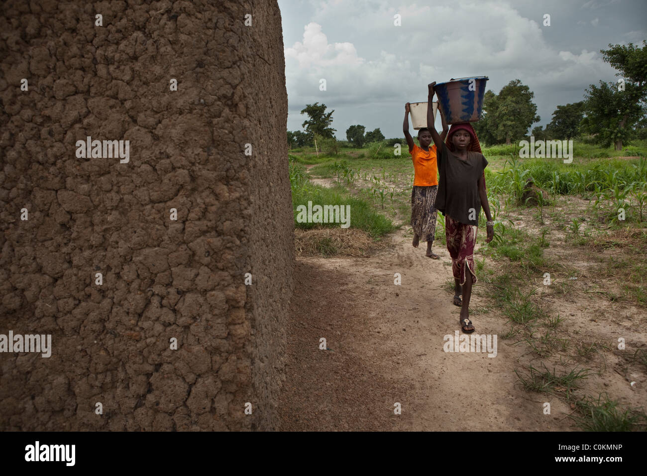 Le ragazze portano a casa di acqua da un pozzo in Safo, Mali, Africa occidentale. Foto Stock