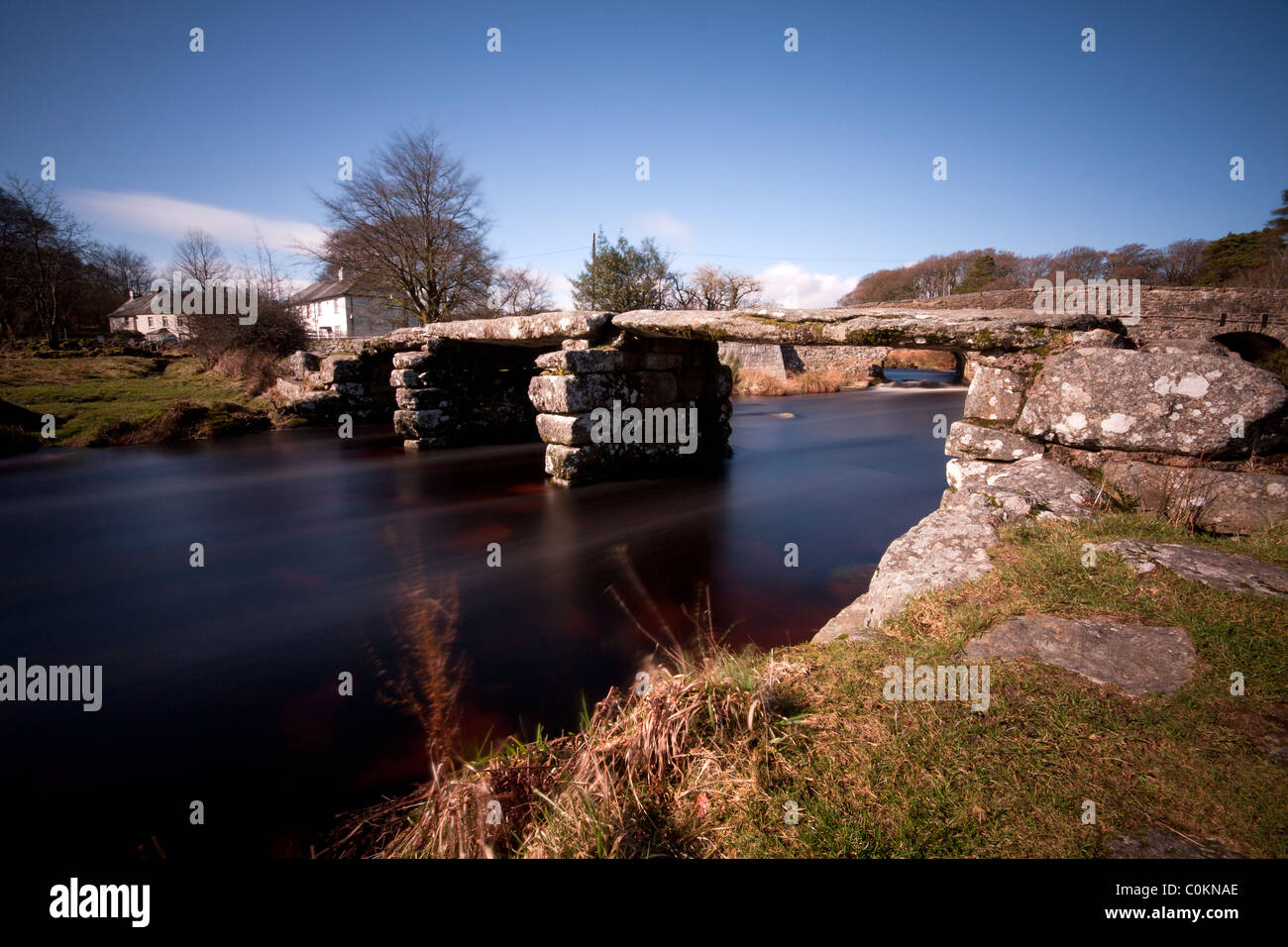 Esposizione lento che mostra il flusso del fiume Dart sotto il battaglio ponte a ponte Post, Dartmoor Foto Stock