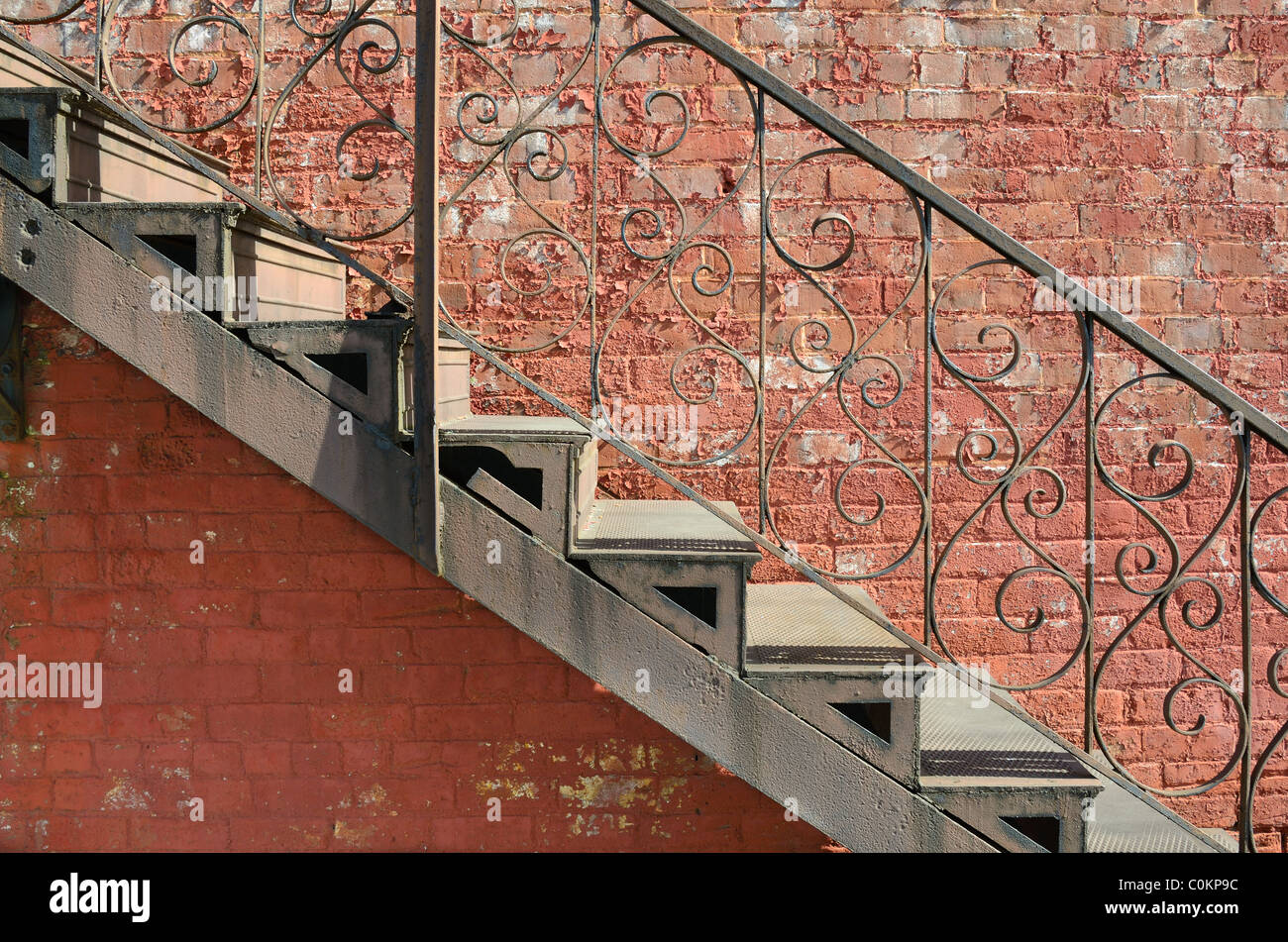 Vista astratta di scale contro un lato esterno della parete di mattoni. Foto Stock