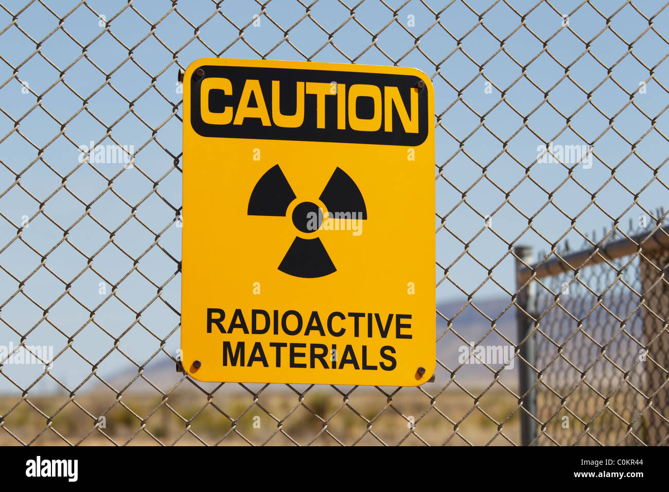 Un messaggio di attenzione materiali radioattivi segno su un recinto di filo, Trinità Sito, Nuovo Messico. Foto Stock
