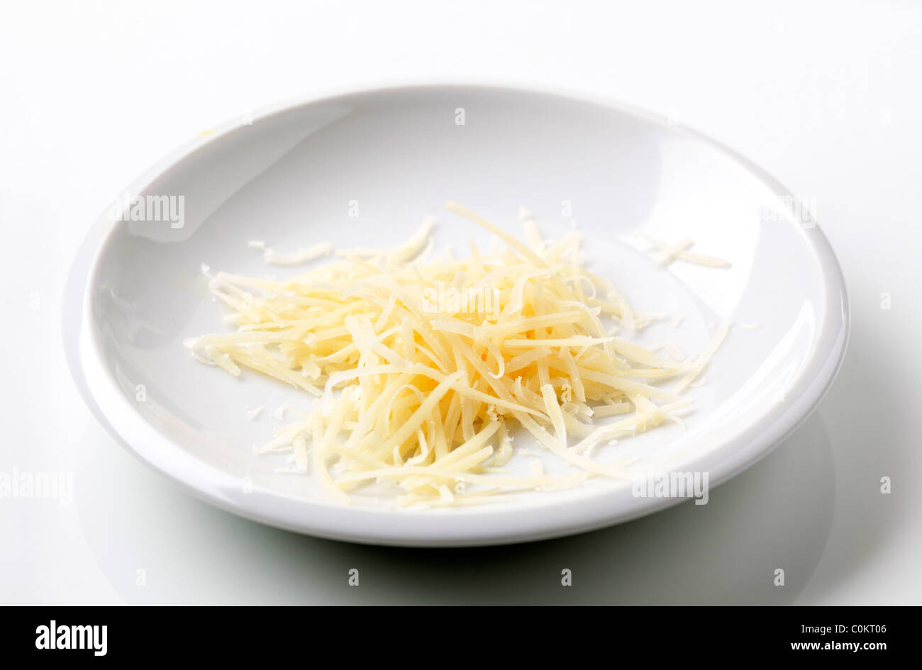 Cumulo di formaggio grattugiato su una piastra Foto Stock