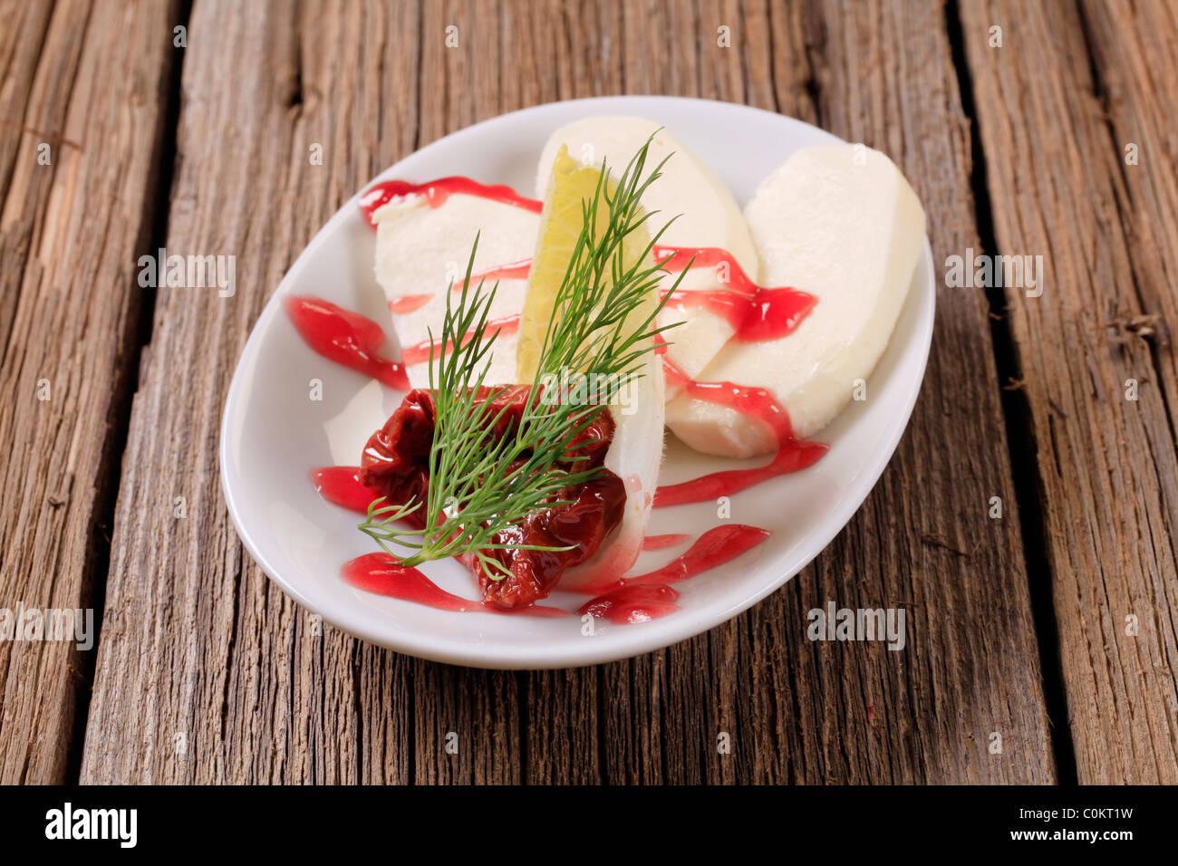 Mozzarella con guarnite di lampone e di riduzione di aceto balsamico Foto Stock