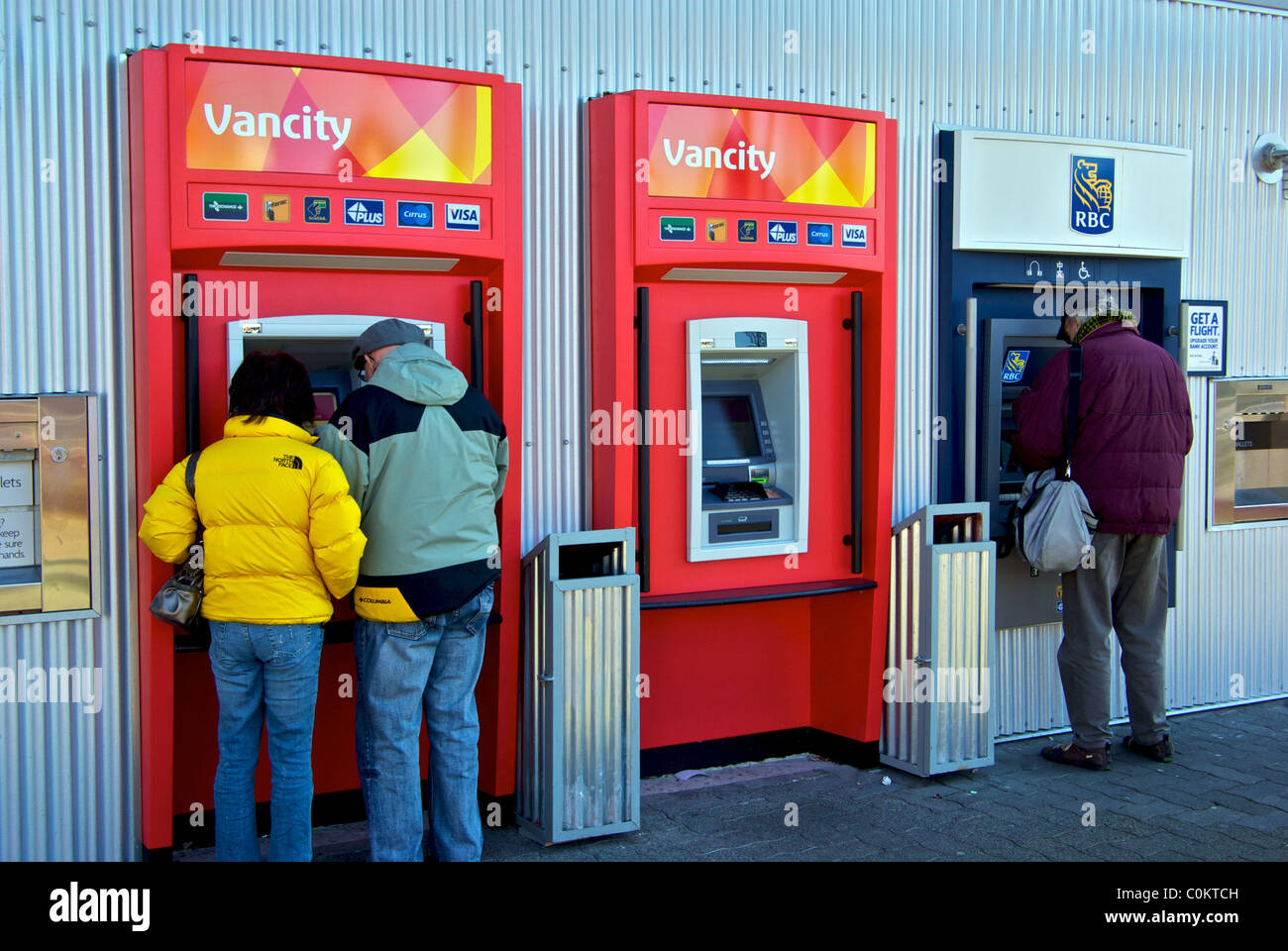 Persone che utilizzano la fila di sportelli automatici bancari Granville Island Vancouver Foto Stock