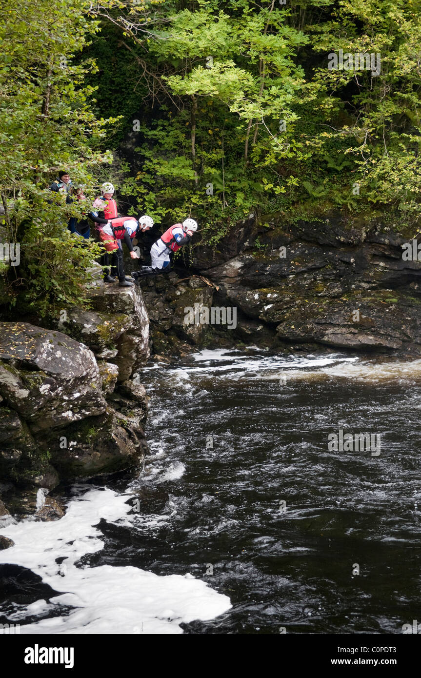 Gorge walking, noto anche come canyoning a cadute di Falloch appena fuori la A82 a poche miglia a sud di Crianlarich, Scozia Foto Stock