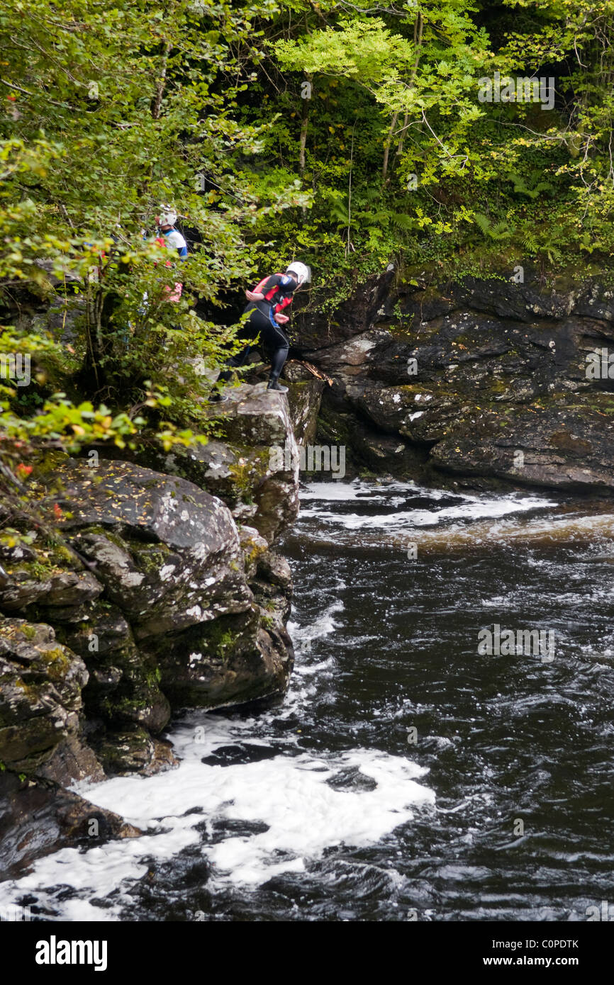 Gorge walking, noto anche come canyoning a cadute di Falloch appena fuori la A82 a poche miglia a sud di Crianlarich, Scozia Foto Stock