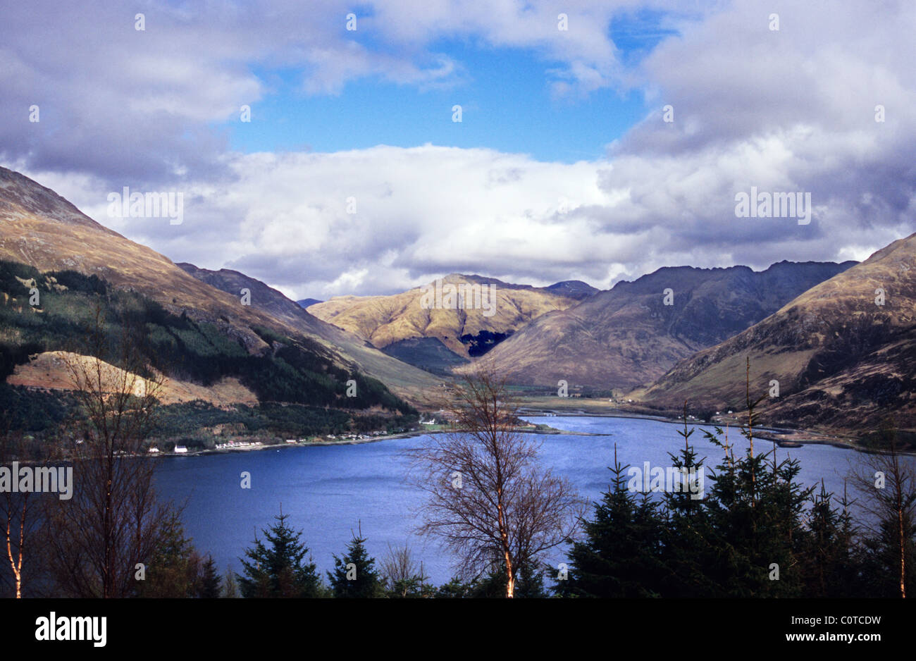 Loch Carron, Highlands Scozzesi. Neve rivestiti montagne, acqua azzurra del loch, blu cielo nuvoloso. Foto Stock