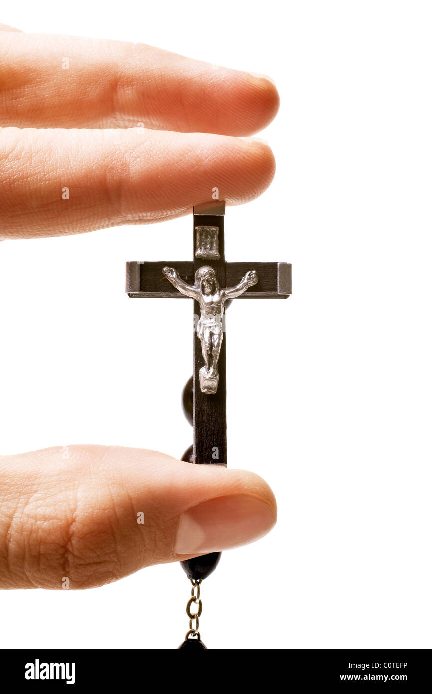 Gli uomini le dita tenendo premuto il crocifisso cattolica isolati su sfondo bianco Foto Stock
