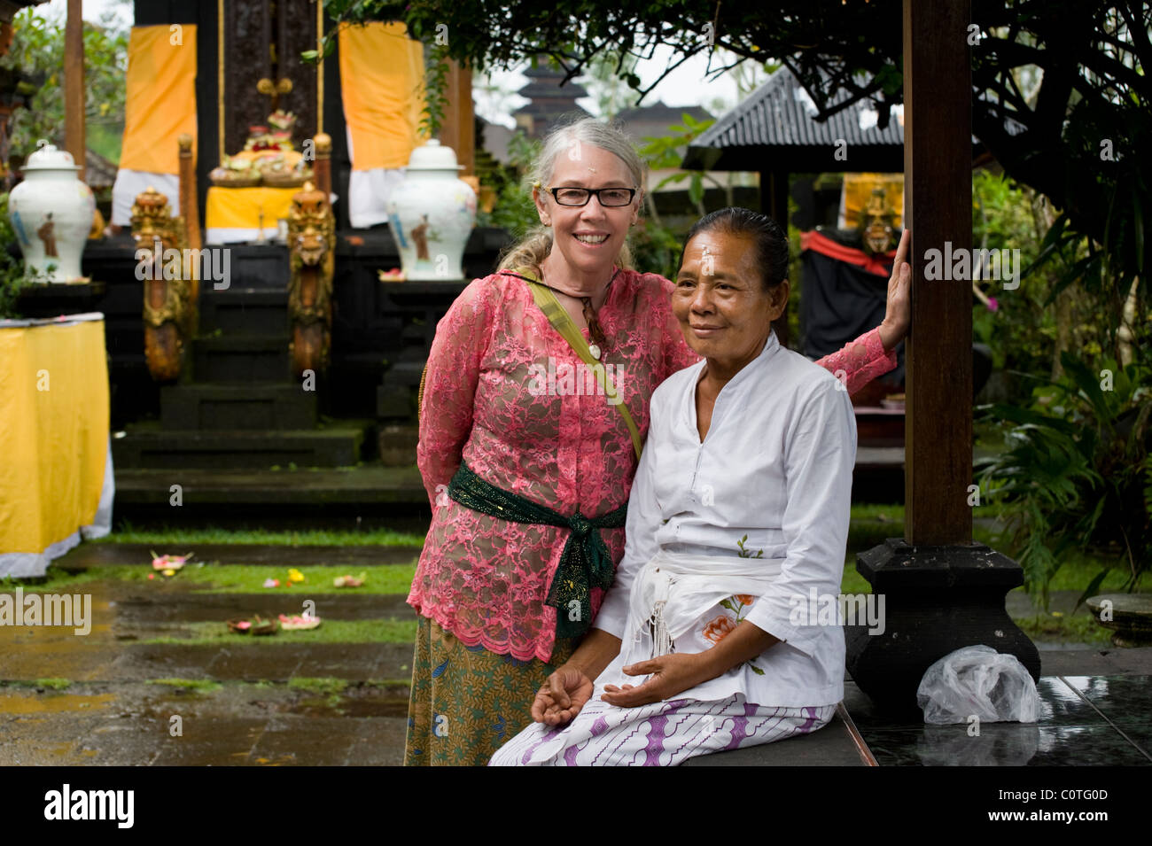 Un turista a Bali il più famoso tempio indù, Besakih, il Tempio madre, pone con un sacerdote Balinese dopo essere stata benedetta. Foto Stock