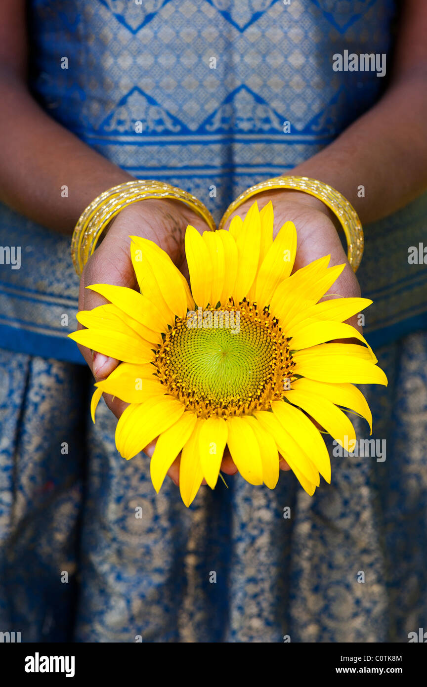 Giovane ragazza indiana holding di semi di girasole. Andhra Pradesh, India Foto Stock
