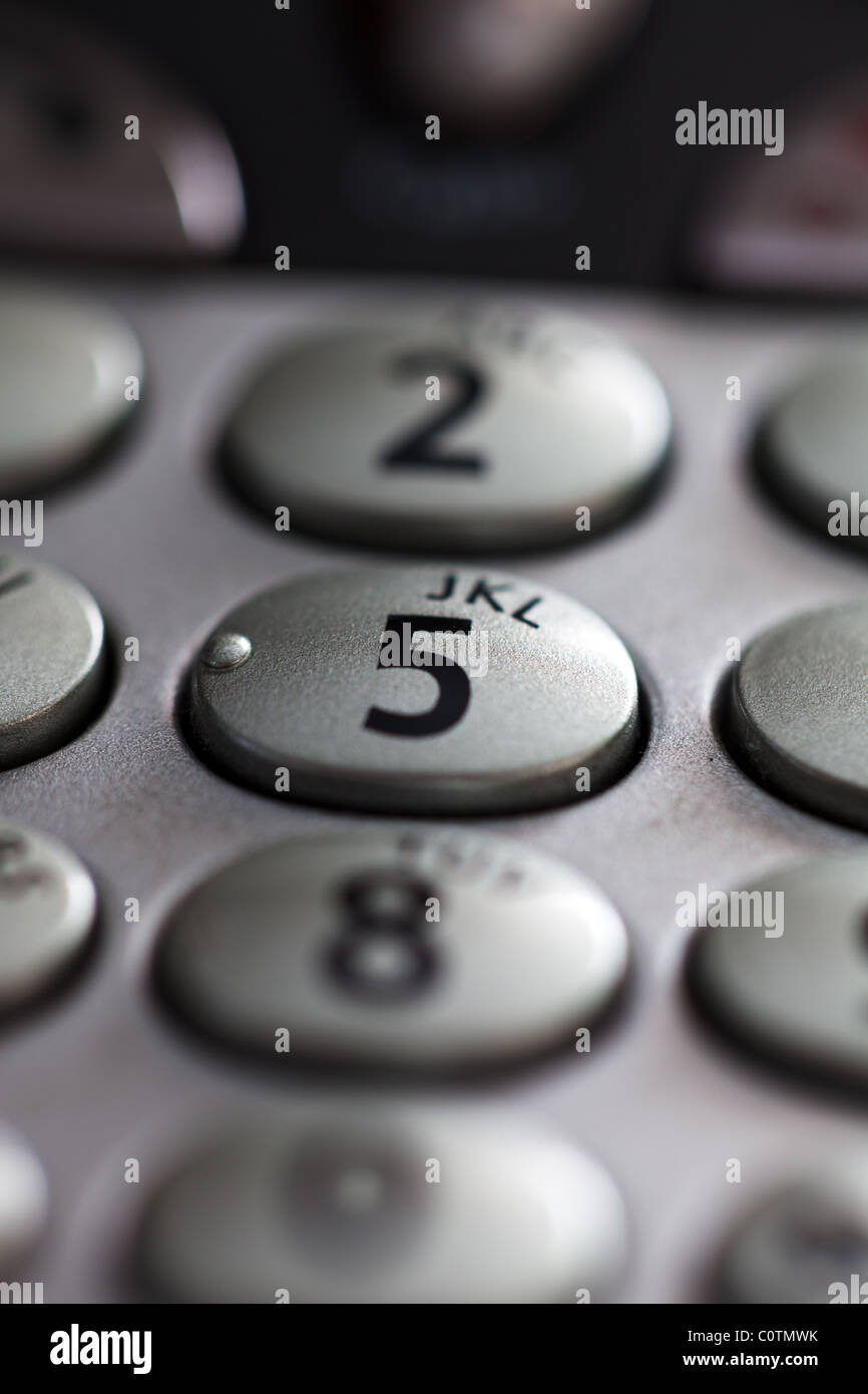 Un primo piano di una tastiera del telefono mostra il numero 5 in una messa a fuoco nitida e mostra anche alcune lettere dell'alfabeto Foto Stock