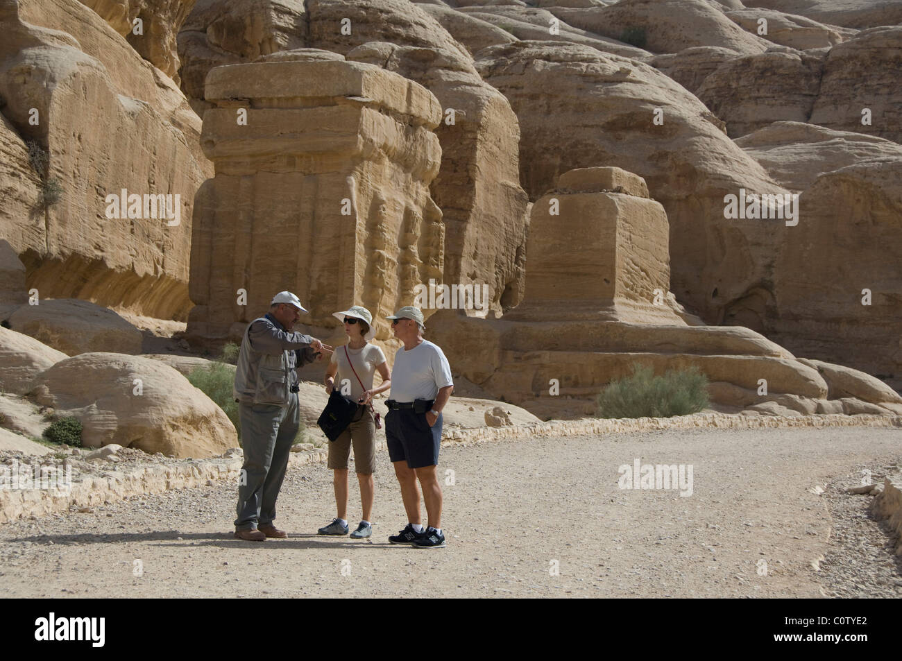 Giordania, Nabataean antica città di Petra. I turisti con guida nella parte anteriore delle rovine del Djinn blocchi. Foto Stock